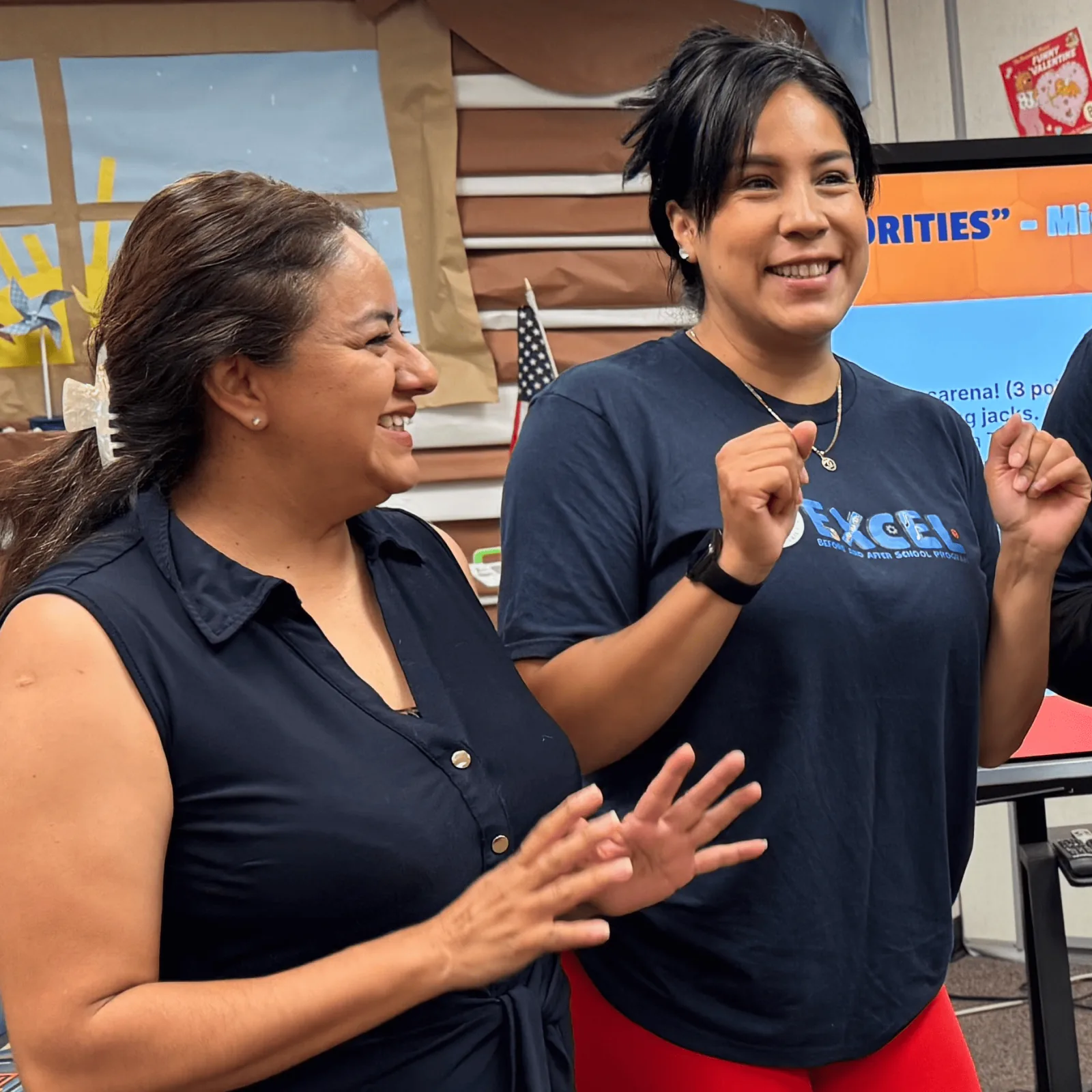 After-school program staff high-fiving in a school library